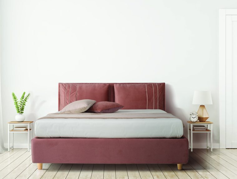 Light, cute and cozy home bedroom interior with unmade bed, pink plaid and cushions on empty white wall background. 3D rendering.