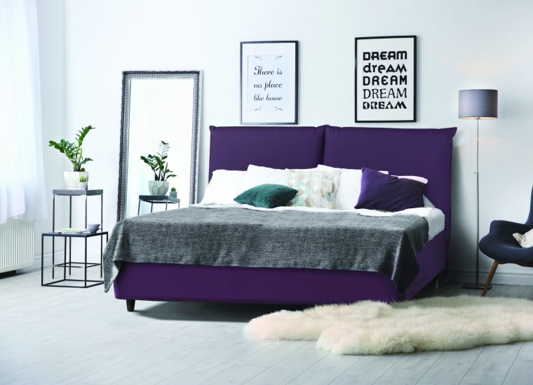 Elegant room interior with large comfortable bed and armchair
